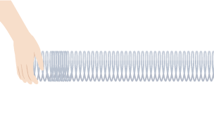 A hand is holding a stretched metal coil. Ten coils near the left-hand end are compressed.